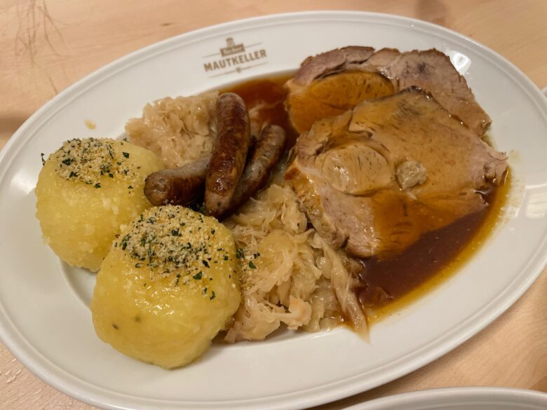 シュバイネブラーテンとニュルンベルクソーセージの盛り合わせ。クヌーデルとザウアークラウト添え
