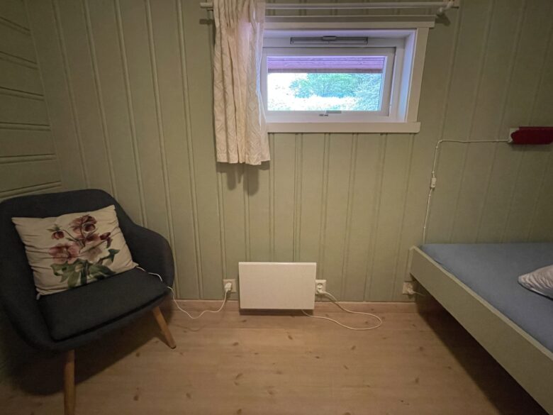 Flåm Hostel & Cabinsの個室。椅子とベッドの間にパネル暖房器具。